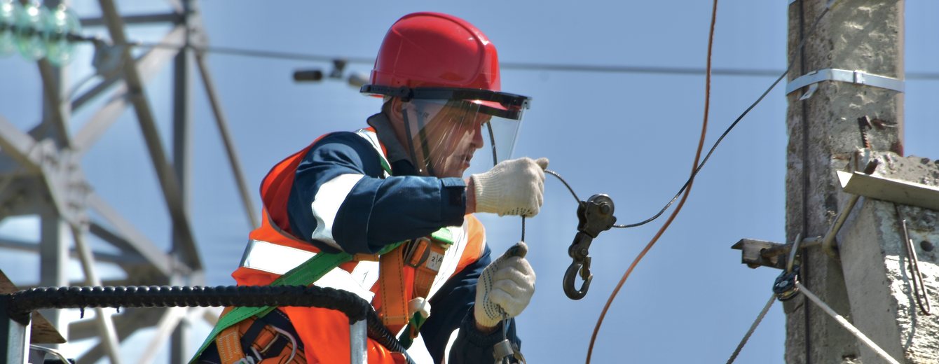 Electrician working on overhead infrastructure